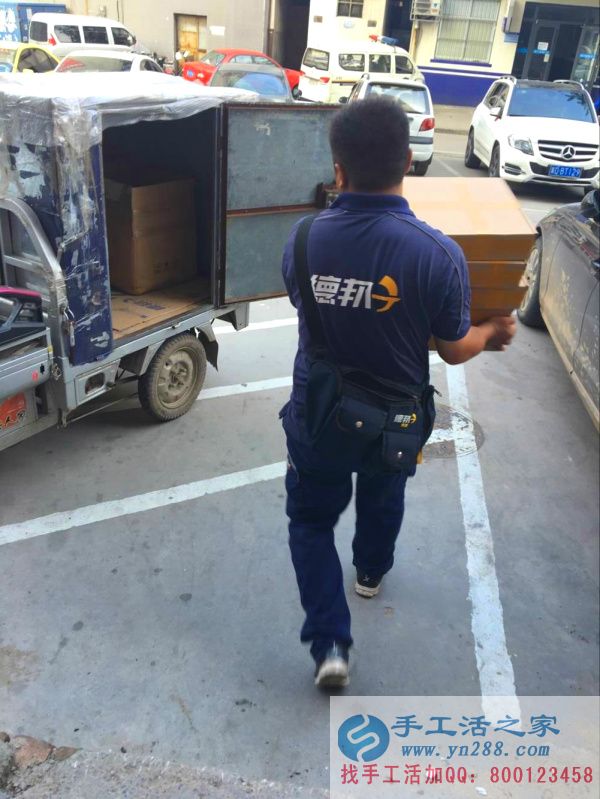 快遞小哥搬著貨物正在向車(chē)走去